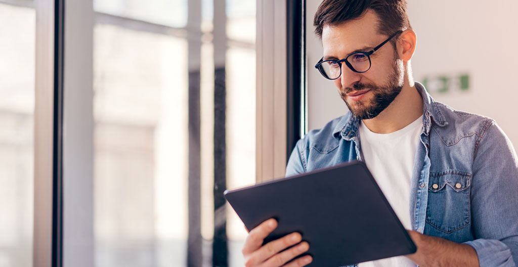 Person reading constipation FAQ on tablet with tea