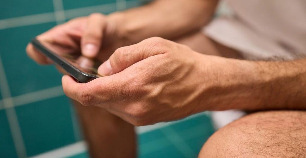 Person tracking constipation symptoms on smartphone health app